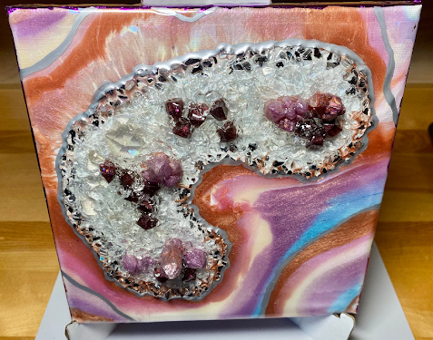 A square canvas art print featuring a geode-like design with clear crystal formations, purple amethyst crystals, and a silver metallic border, set against a colorful marbled background of pink, purple, orange, and blue swirls.