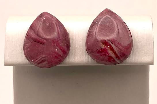 A pair of teardrop-shaped stud earrings with a marbled burgundy and pink stone pattern, displayed on a white jewelry stand against a light gray background.